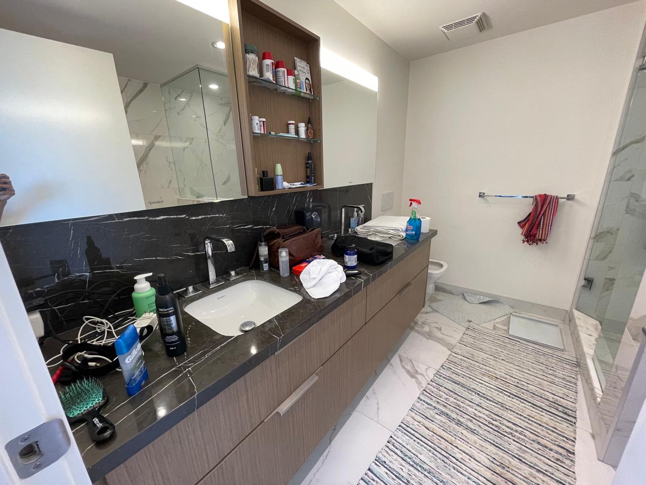 Cluttered bathroom vanity before a Tidy Tribe clean